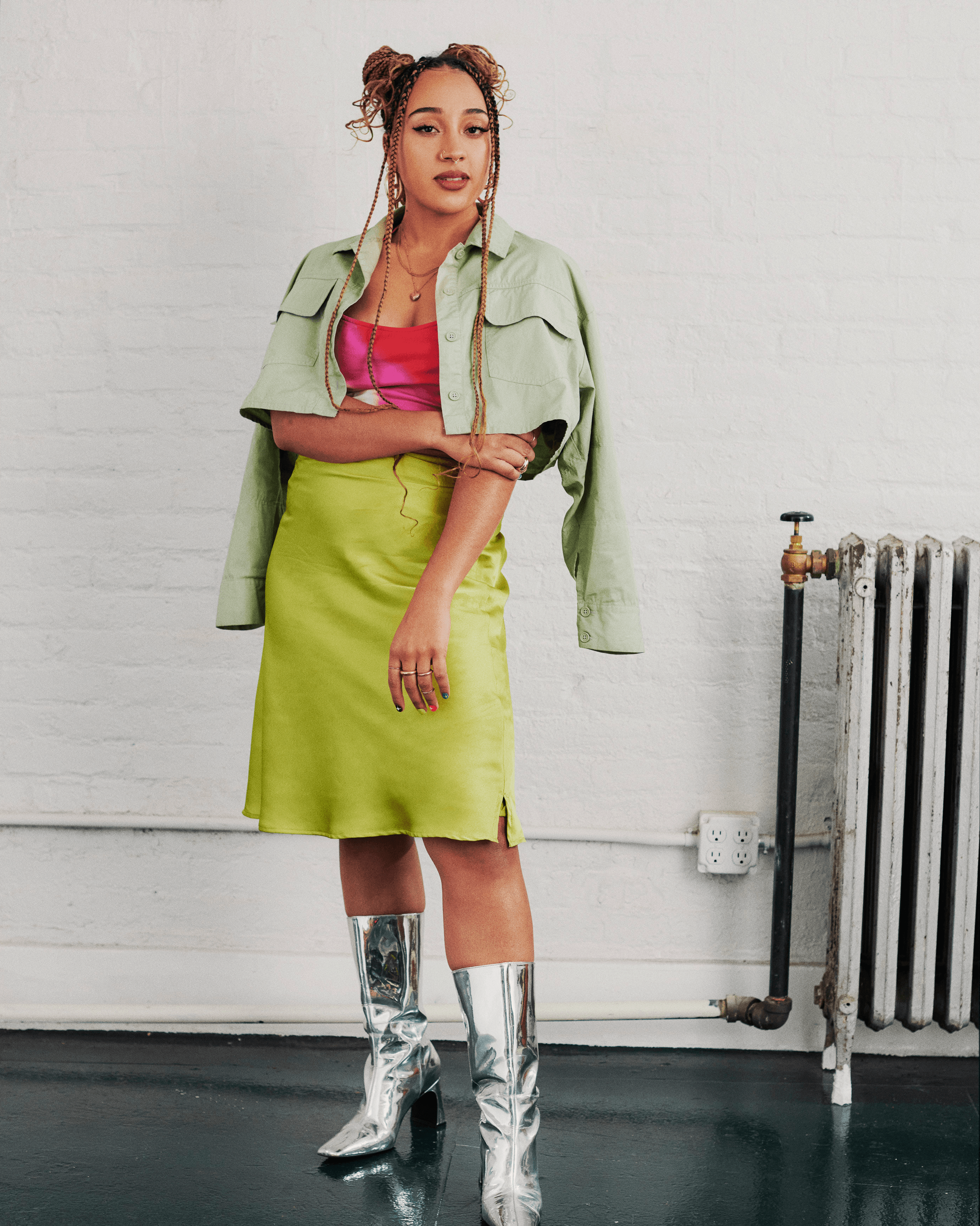 A profile portrait of Annika Hansteen-Izora standing with her arm across her body.