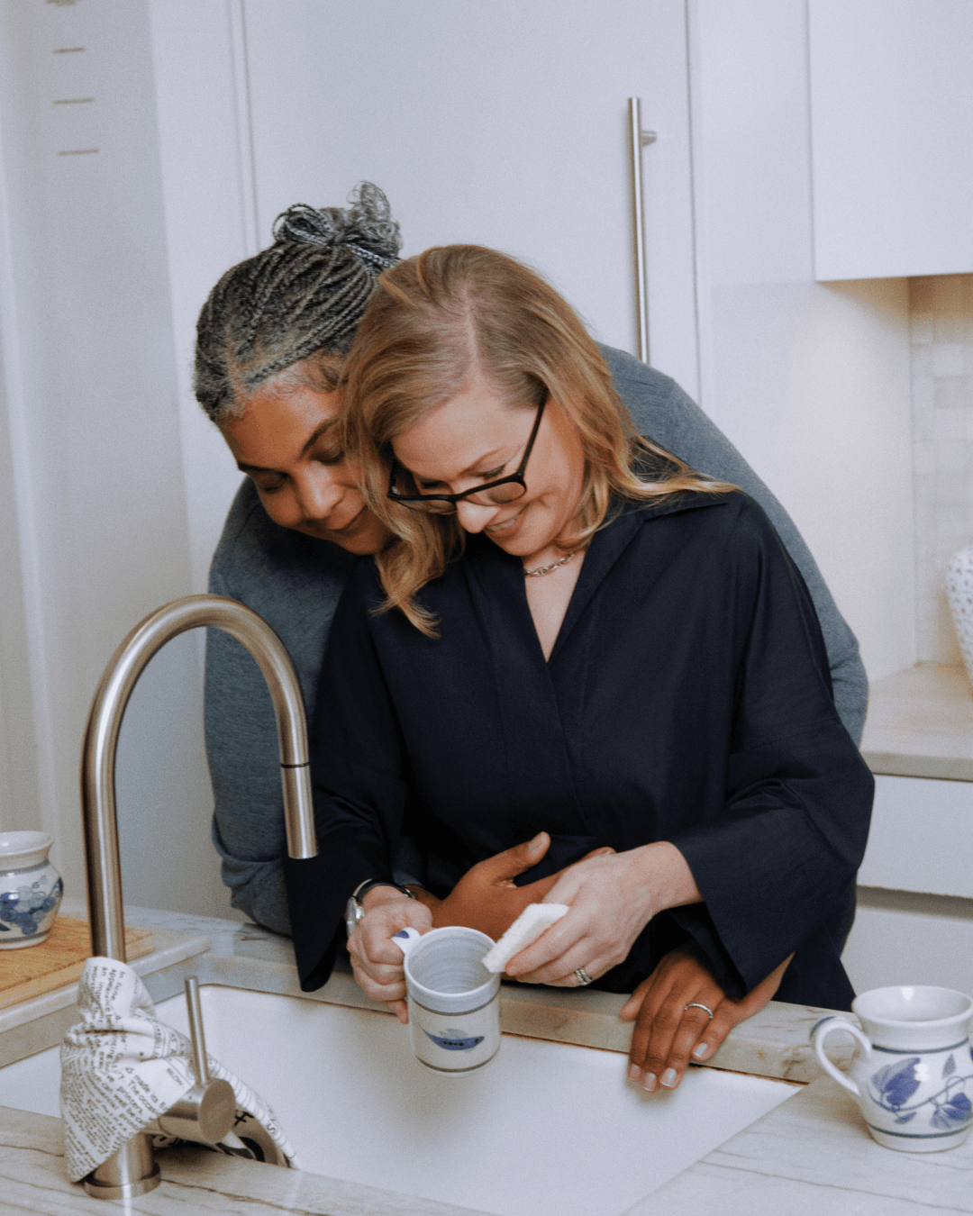 Roxane and Debbie do dishes together over the sink