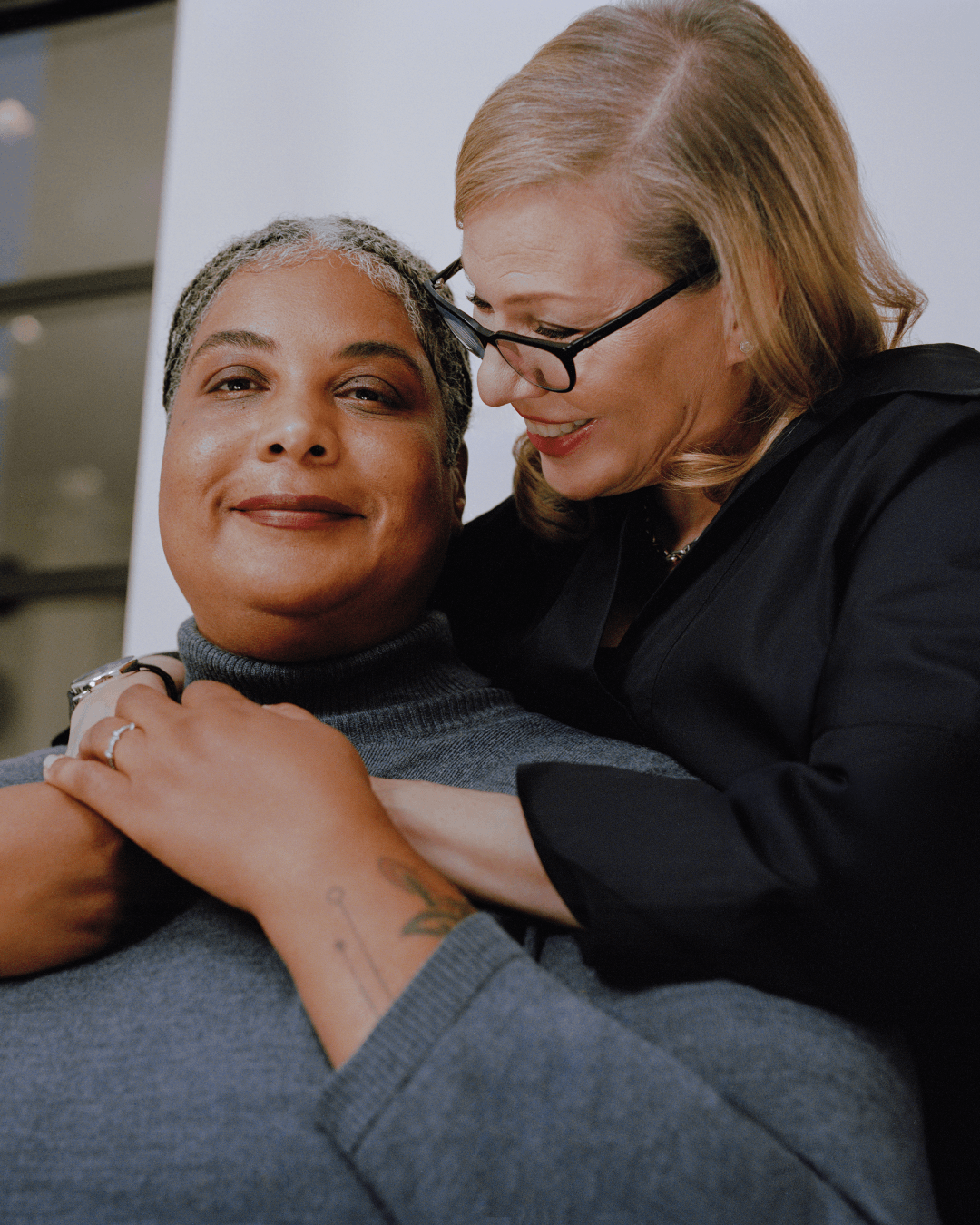 Roxane looks at the camera, while Debbie embraces her