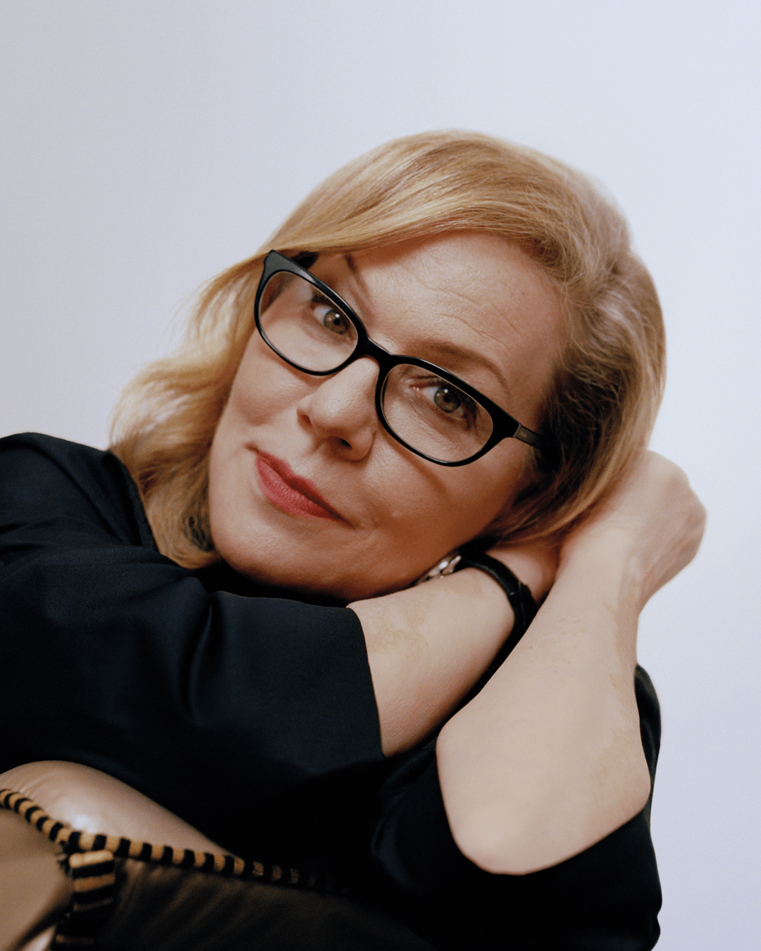 Debbie is leaning on her arms, looking into the camera.