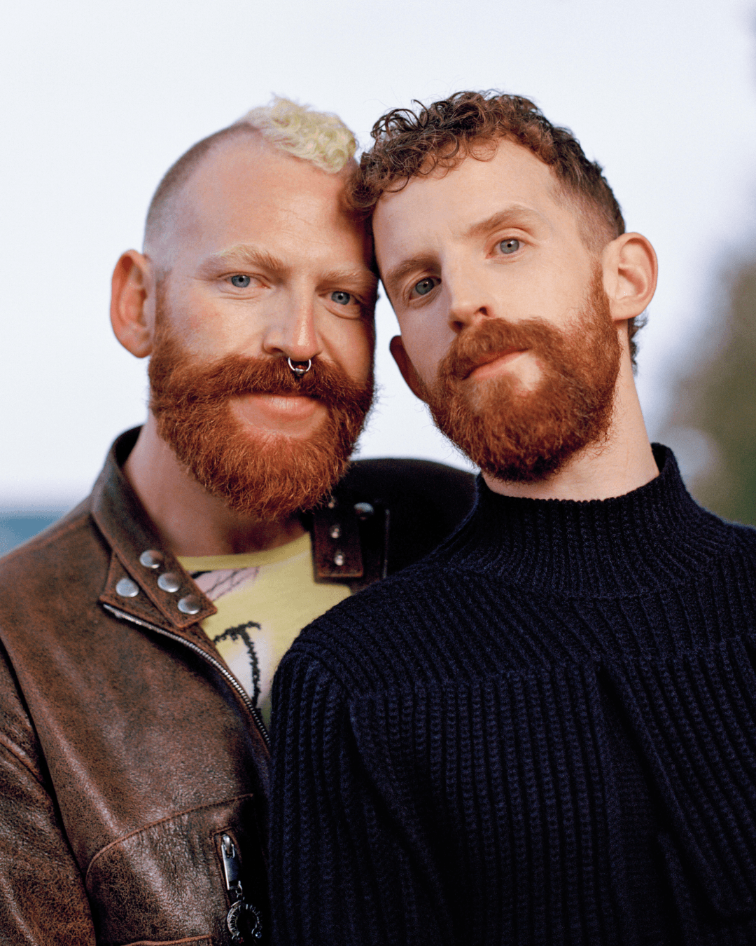Tom and Shugs stand together, leaning on eachother in front of trees